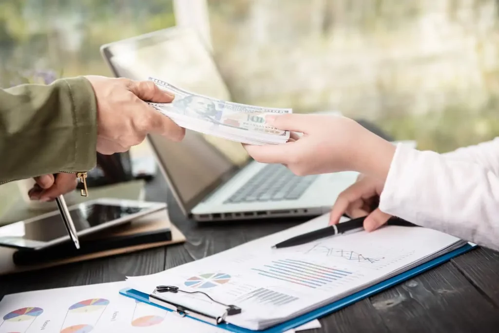 businessman giving money his partner while making contract