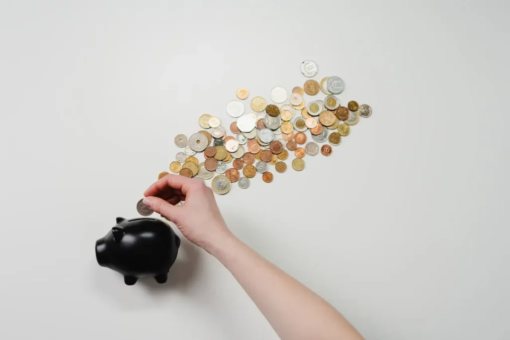 a hand putting coins in piggybank